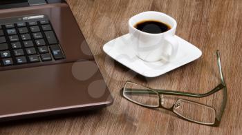Espresso coffee with glasses on wood floor with laptop