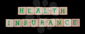 Green letters on old wooden blocks (health, insurance)