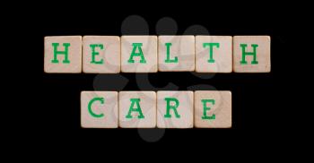 Green letters on old wooden blocks (health, care)