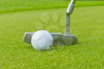 Golf ball on front of a driver at driving range