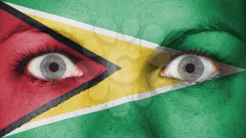 Close up of eyes. Painted face with flag of Guyana