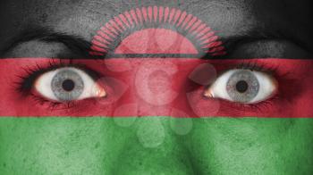 Close up of eyes. Painted face with flag of Malawi