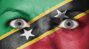 Close up of eyes. Painted face with flag of Saint Kitts and Nevis