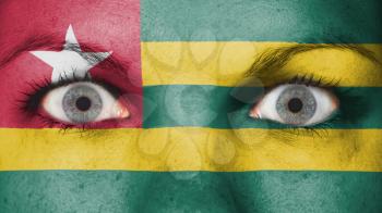 Close up of eyes. Painted face with flag of Togo