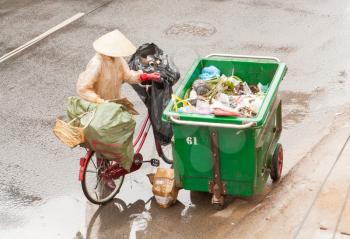 DA LAT, VIETNAM - 28 JULY 2012: Government worker separates the waste on the street for recycling. Pollution is a big problem in Vietnam nowadays. Da Lat, Vietnam, 28 JULY 2012