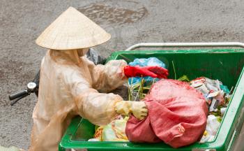 DA LAT, VIETNAM - 28 JULY 2012: Government worker separates the waste on the street for recycling. Pollution is a big problem in Vietnam nowadays. Da Lat, Vietnam, 28 JULY 2012