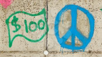 Simple graffity on a concrete wall, 100 dollar and a piece sign