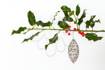 Very old silver christmas ball hanging from a twig (butchers broom), isolated