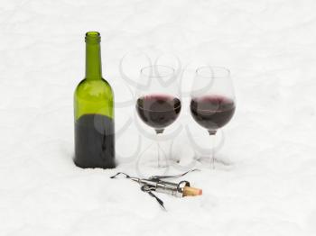 Bottle of red wine and wineglasses isolated in the cold snow