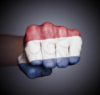 Front view of punching fist on gray background, flag of Holland