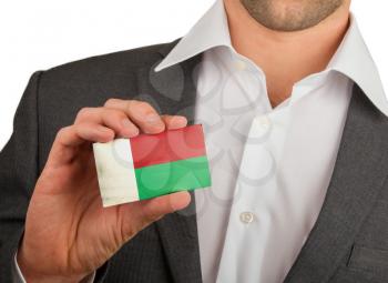Businessman is holding a business card, flag of Madagascar