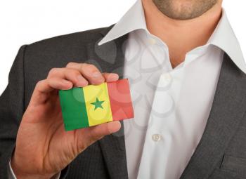 Businessman is holding a business card, flag of Senegal