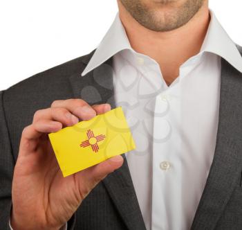 Businessman is holding a business card, flag of New Mexico