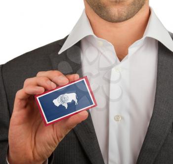 Businessman is holding a business card, flag of Wyoming