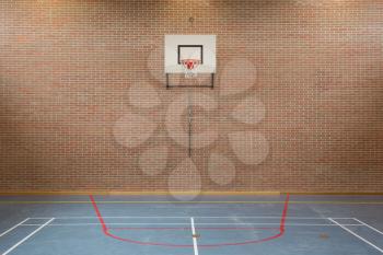 Interior of a gym at school, jumping high at the basket