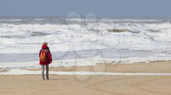 Woman walking on the beach during a storm