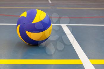 Blue and yellow ball on blue court at break time, school gym