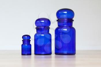 Blue glass jars isolated on a wooden table