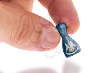 Hand holding wooden pawn with a flag painting, selective focus, Louisiana