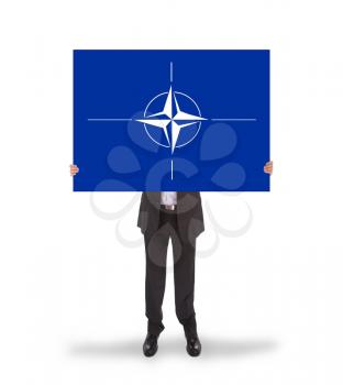 Businessman holding a big card, NATO symbol, isolated on white