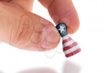 Hand holding wooden pawn with a flag painting, selective focus, Liberia