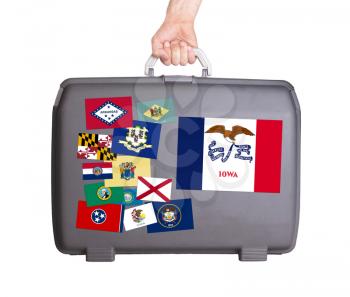 Used plastic suitcase with stains and scratches, stickers of US States, Iowa