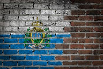 Very old dark red brick wall texture with flag - San Marino