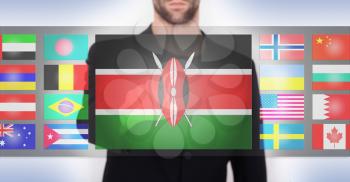 Hand pushing on a touch screen interface, choosing language or country, Kenya