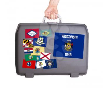 Used plastic suitcase with stains and scratches, stickers of US States, Wisconsin