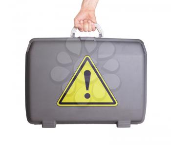 Used plastic suitcase with stains and scratches, danger, exclamation mark