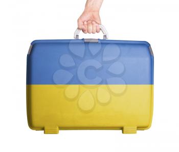 Used plastic suitcase with stains and scratches, printed with flag, Ukraine