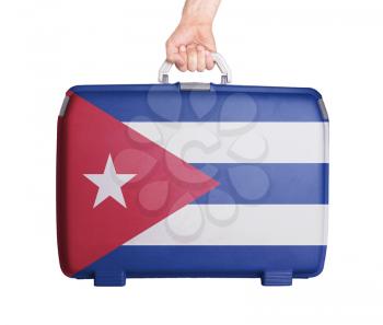 Used plastic suitcase with stains and scratches, printed with flag, Cuba