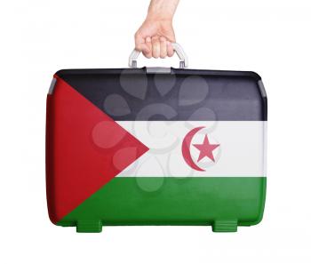 Used plastic suitcase with stains and scratches, printed with flag, Western Sahara