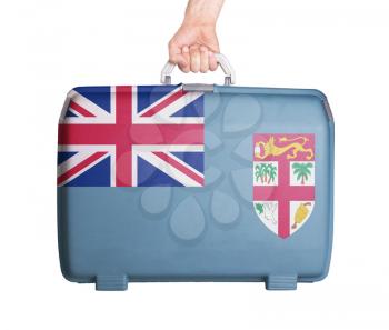 Used plastic suitcase with stains and scratches, printed with flag, Fiji