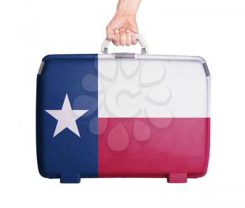 Used plastic suitcase with stains and scratches, printed with flag, Texas