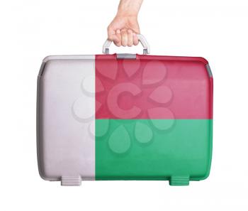 Used plastic suitcase with stains and scratches, printed with flag, Madagascar