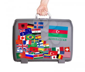 Used plastic suitcase with lots of small stickers, large sticker of Azerbaijan