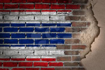 Dark brick wall texture with plaster - flag painted on wall - Thailand