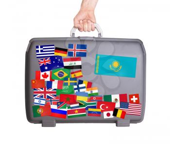 Used plastic suitcase with lots of small stickers, large sticker of Kazakhstan