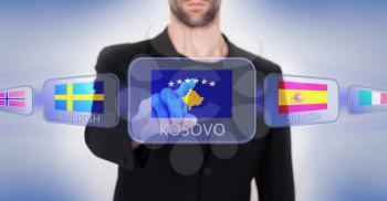 Hand pushing on a touch screen interface, choosing language or country, Kosovo