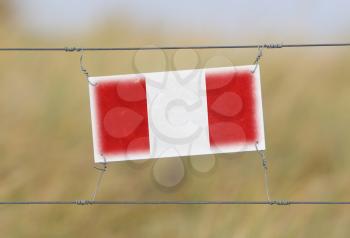 Border fence - Old plastic sign with a flag - Peru