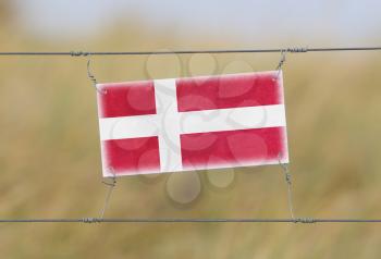 Border fence - Old plastic sign with a flag - Denmark
