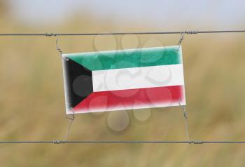 Border fence - Old plastic sign with a flag - Kuwait