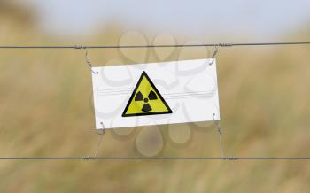 Border fence - Old plastic sign with a flag - Radiation