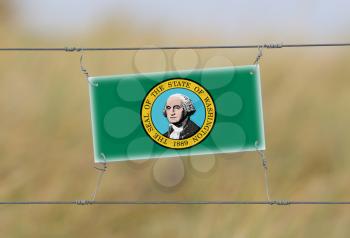 Border fence - Old plastic sign with a flag - Washington