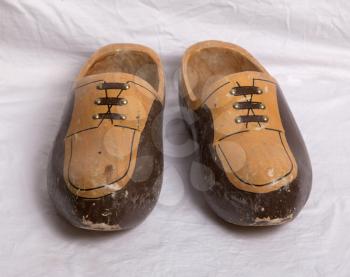 Pair of traditional Dutch wooden shoes on a white sheet