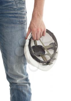 Male engineer in jeans holding white hardhat, isolated