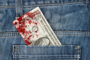 Macro shot of trendy jeans with american 1 dollar bill on its pocket, blood