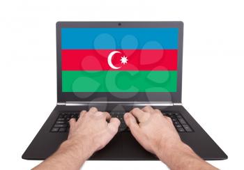 Hands working on laptop showing on the screen the flag of Azerbaijan