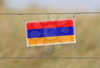 Border fence - Old plastic sign with a flag - Armenia